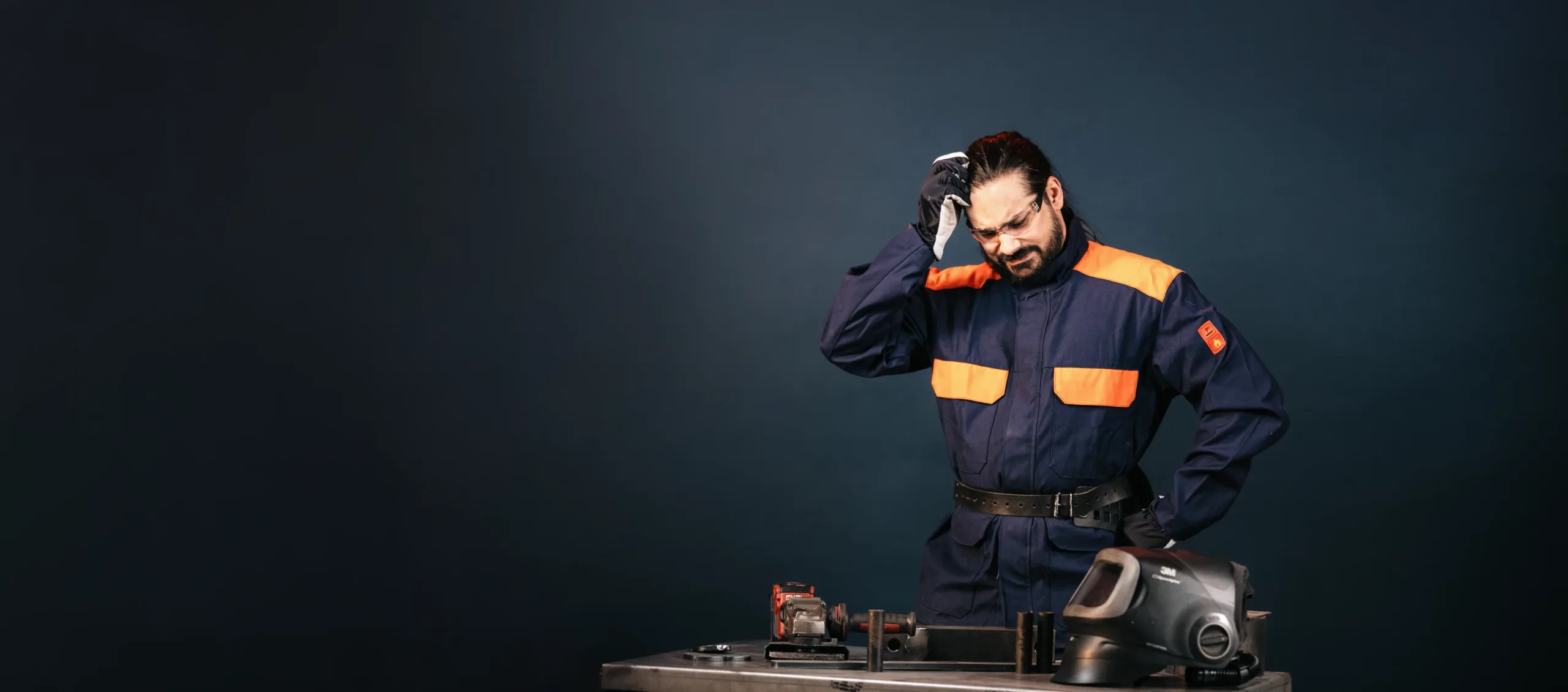 A Wellpack worker at a workbench, thinking