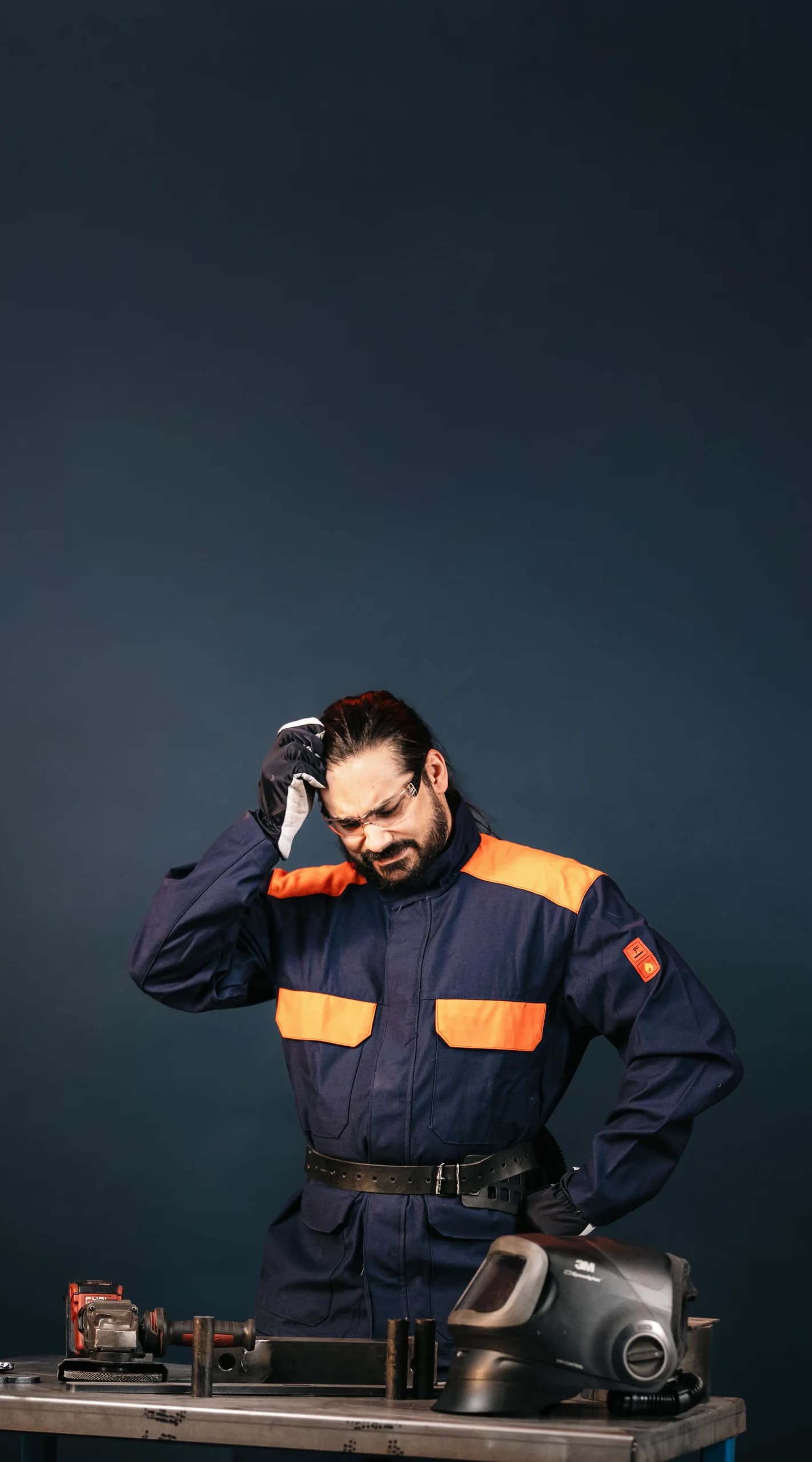 A Wellpack worker at a workbench, thinking