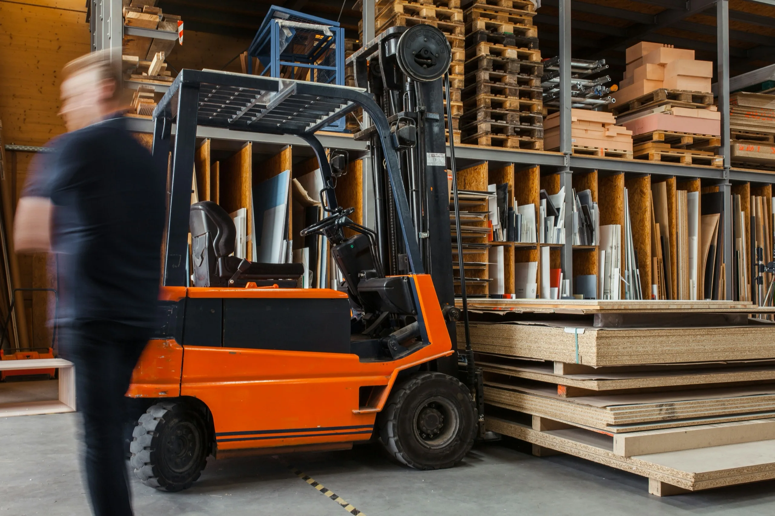 A forklift and a worker in a warehouse